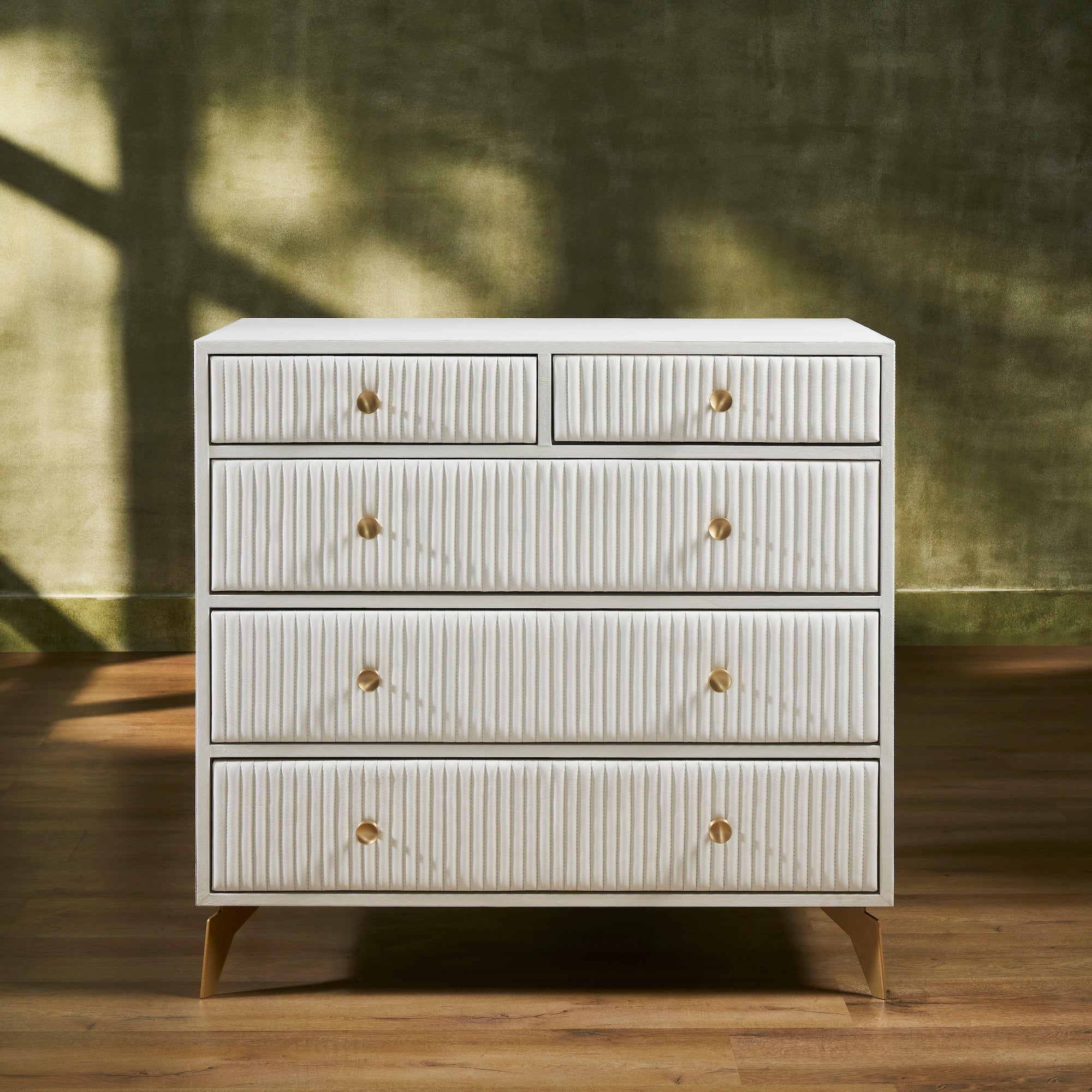 FN-5216-482036_1|Elegant white ribbed leather dresser with gold drawer pulls and tapered legs, offering luxurious modern bedroom storage.