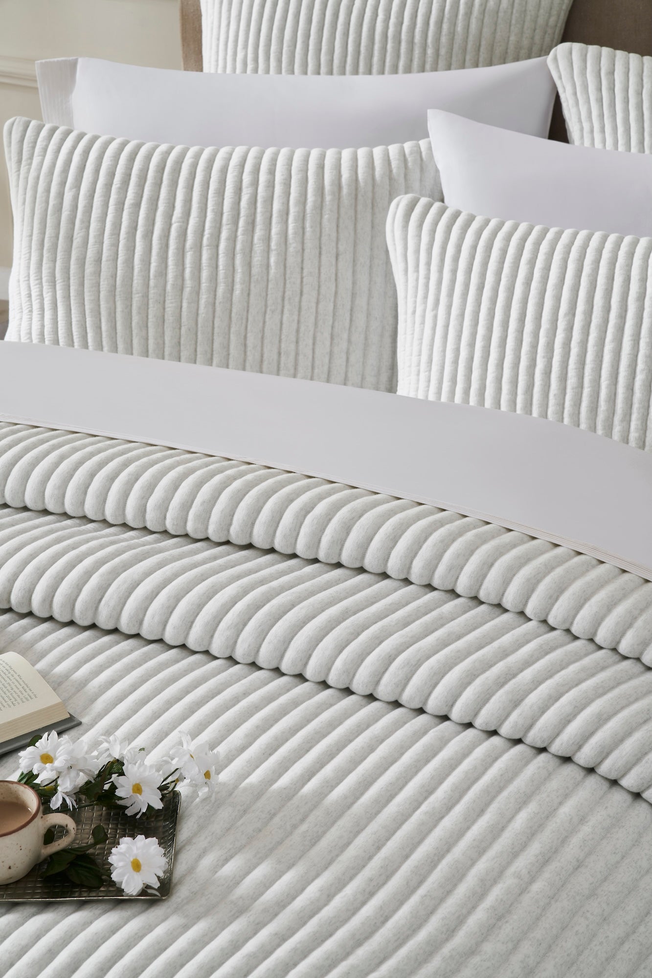 QT-374-9496_4|Serene light grey ribbed quilt and soft pillow shams on a bed, offering elegant textured comfort for a tranquil space.