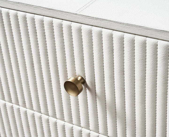 FN-5203-642033_3|Close-up of a sophisticated white dresser with textured vertical channel detailing and a chic brass round knob handle.
