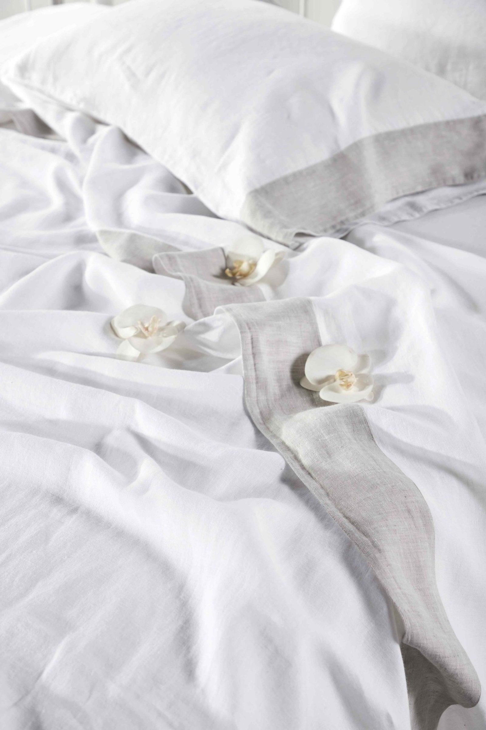 QSS-518-6080_4|Draped white 100% linen sheets with subtle grey stripe, providing a relaxed, luxurious feel for serene bedroom decor.