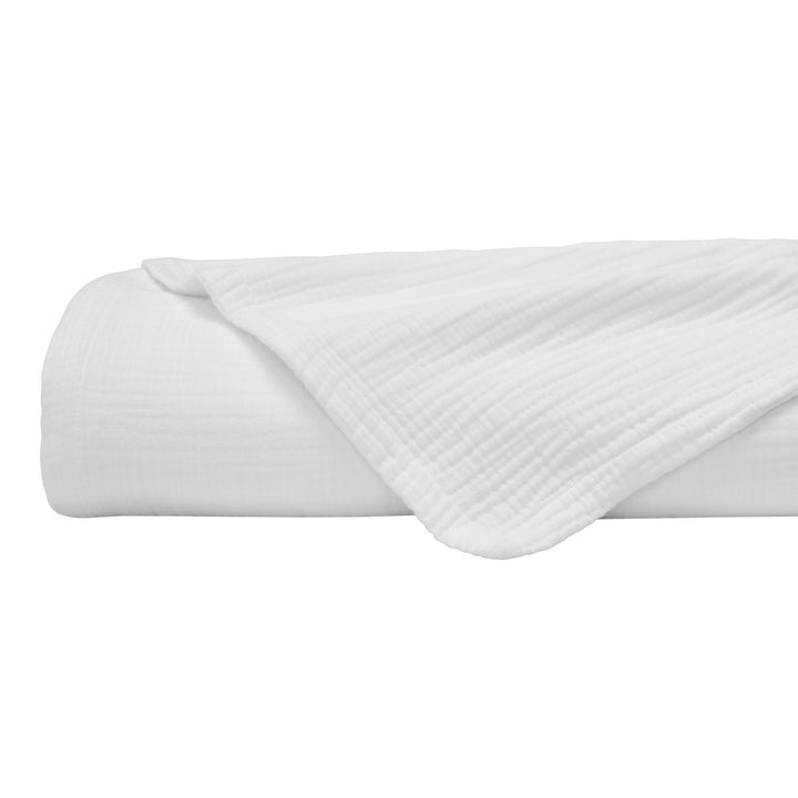 BL-861-9496_6|Neatly rolled white crinkled cotton blanket with a soft texture, perfect as a comfortable throw for any modern living space.