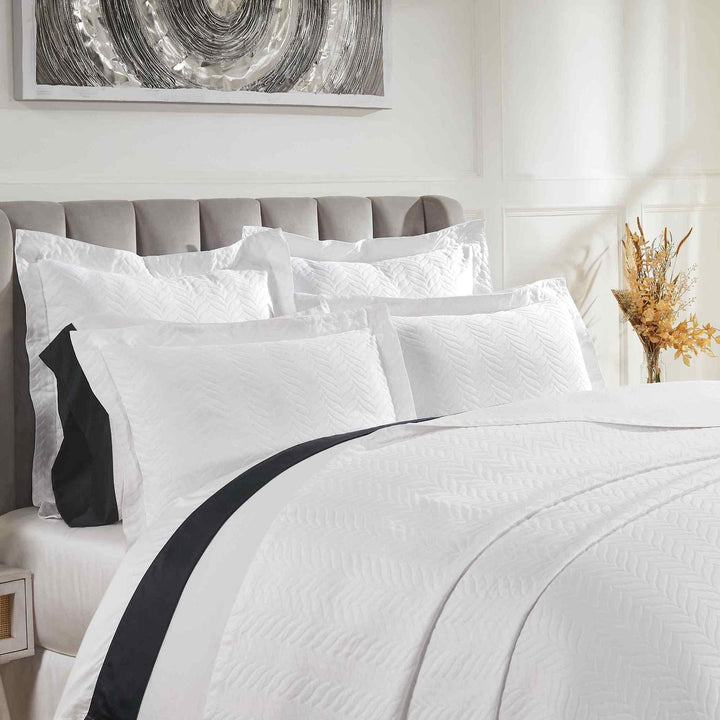 CL-194-9496_2|Close-up of elegant white chevron quilted coverlet, showcasing its intricate pattern and soft texture for luxurious bed styling.