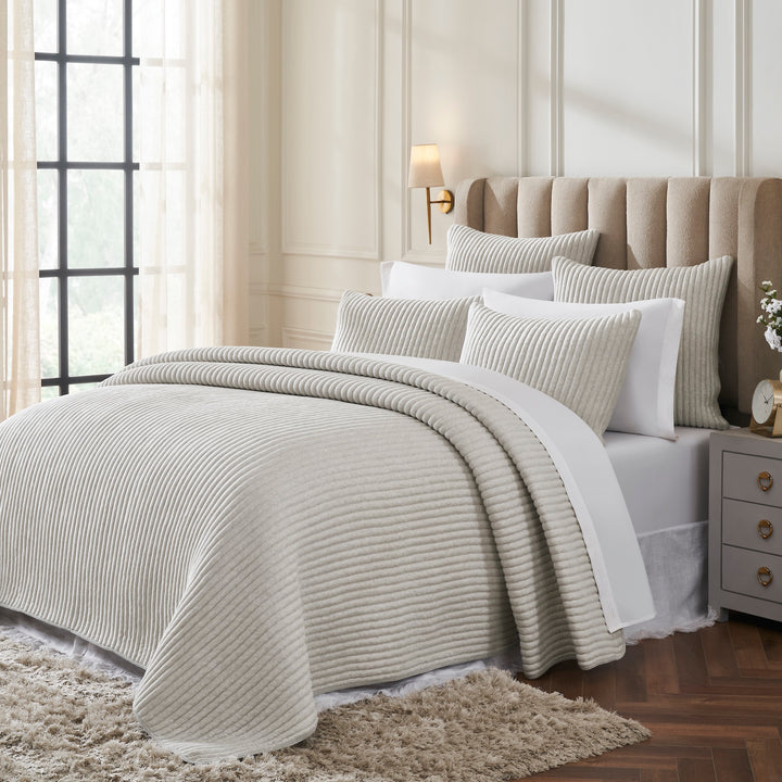 QT-375-9496_2|Ribbed ivory quilt and matching shams draped on a bed, showing soft texture and elegant design for bedding.