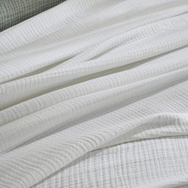 BL-861-9496_5|Close-up of a soft white textured crinkled blanket, showcasing its breathable gauzy cotton fabric and cozy, inviting appearance.