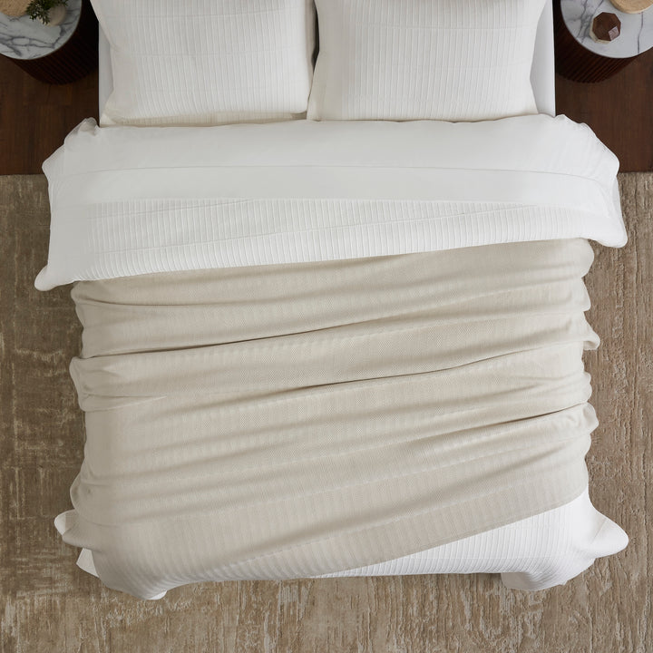 BL-866-11096_4|Cozy cream ribbed knit throw blanket spread over a bed, enhancing bedroom comfort and modern style with its soft texture.