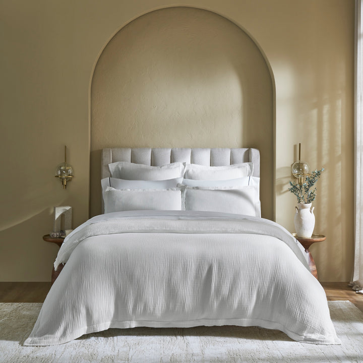 DT-048-10692_1|Pristine white textured duvet cover and matching pillow shams adorning a modern bed, creating a clean, inviting bedroom aesthetic.