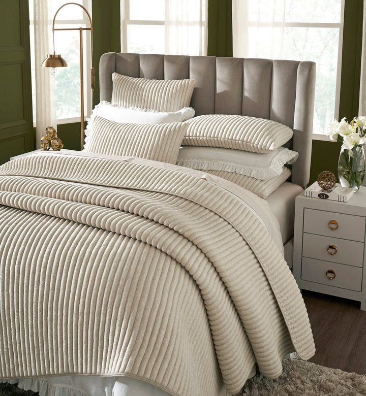 QT-368-11096_3|Close-up of a beige ribbed quilted quilt and pillows, showcasing the soft texture and modern striped design beautifully.