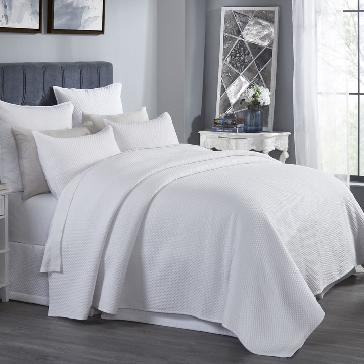 CL-200-9496_2|White quilted coverlet elegantly drapes a queen bed in a bright, modern bedroom, inviting comfort.
