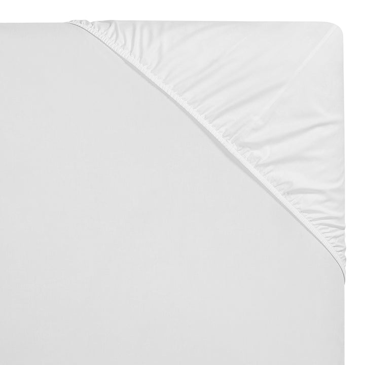 QSS-539-6080_4|Corner view of a crisp white 100% cotton fitted sheet with elastic, showing deep pockets and quality stitching.