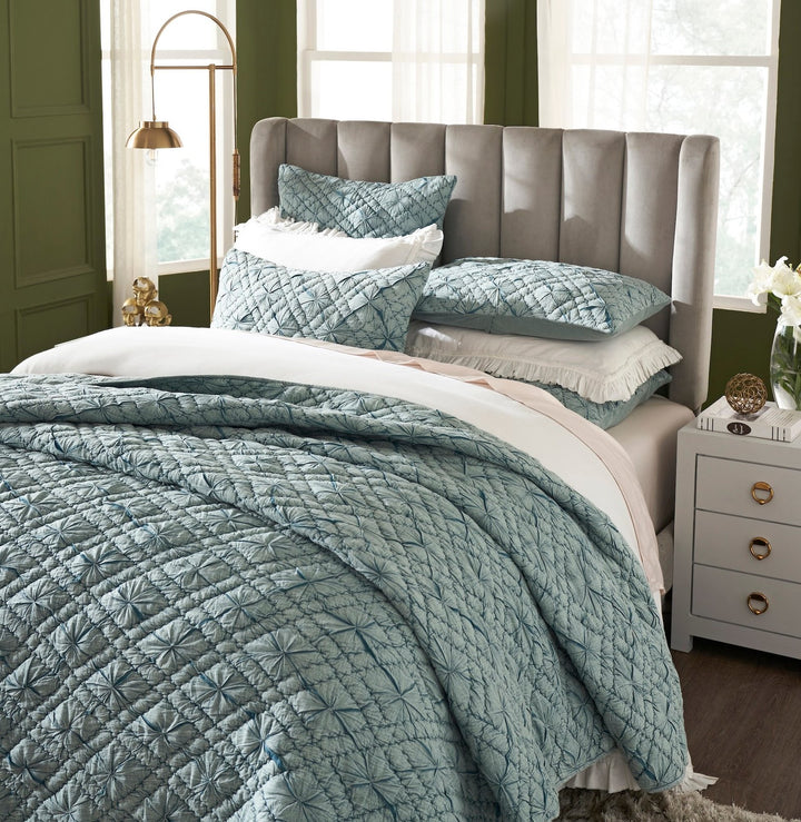 QT-365-11096_3|Elegant teal geometric quilted quilt on a bed with ruffled white sheets, enhancing a vibrant, stylish bedroom.