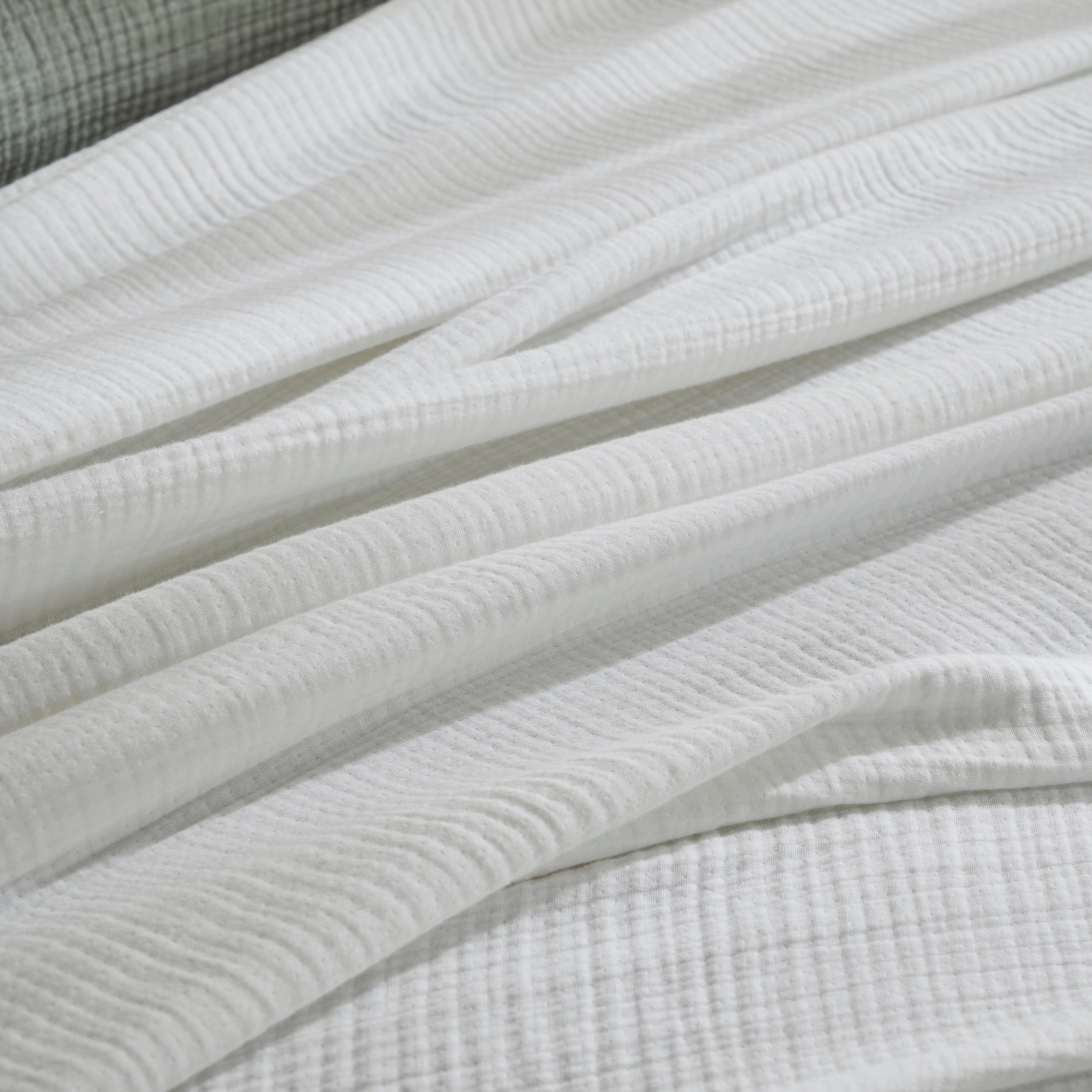 BL-861-9496_5|Close-up of a luxurious white textured blanket, highlighting its soft fabric and inviting comfort for cozy bedding.
