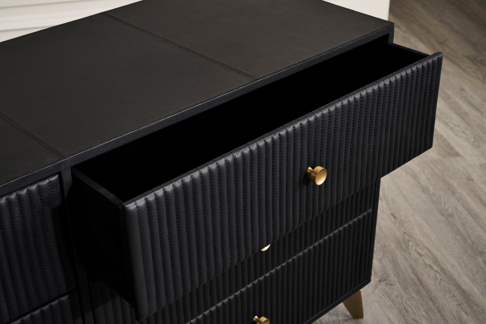FN-5202-642033_6|Detailed close-up of a black modern dresser with open drawer, highlighting the fluted texture and gold knob.