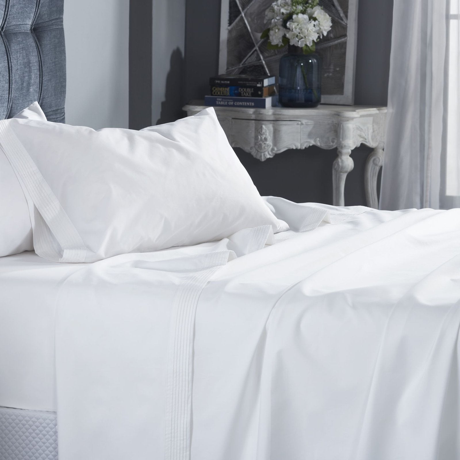 CSS-521-7284_3|Close-up of a perfectly made bed with premium white 100% cotton sheets, accented by stylish pintuck pleats.