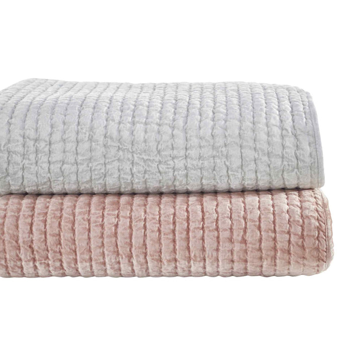QT-354-9496_7|Stack of two plush velvet channel-quilted quilts in dusty pink and light grey. Luxurious, soft bedding layers.