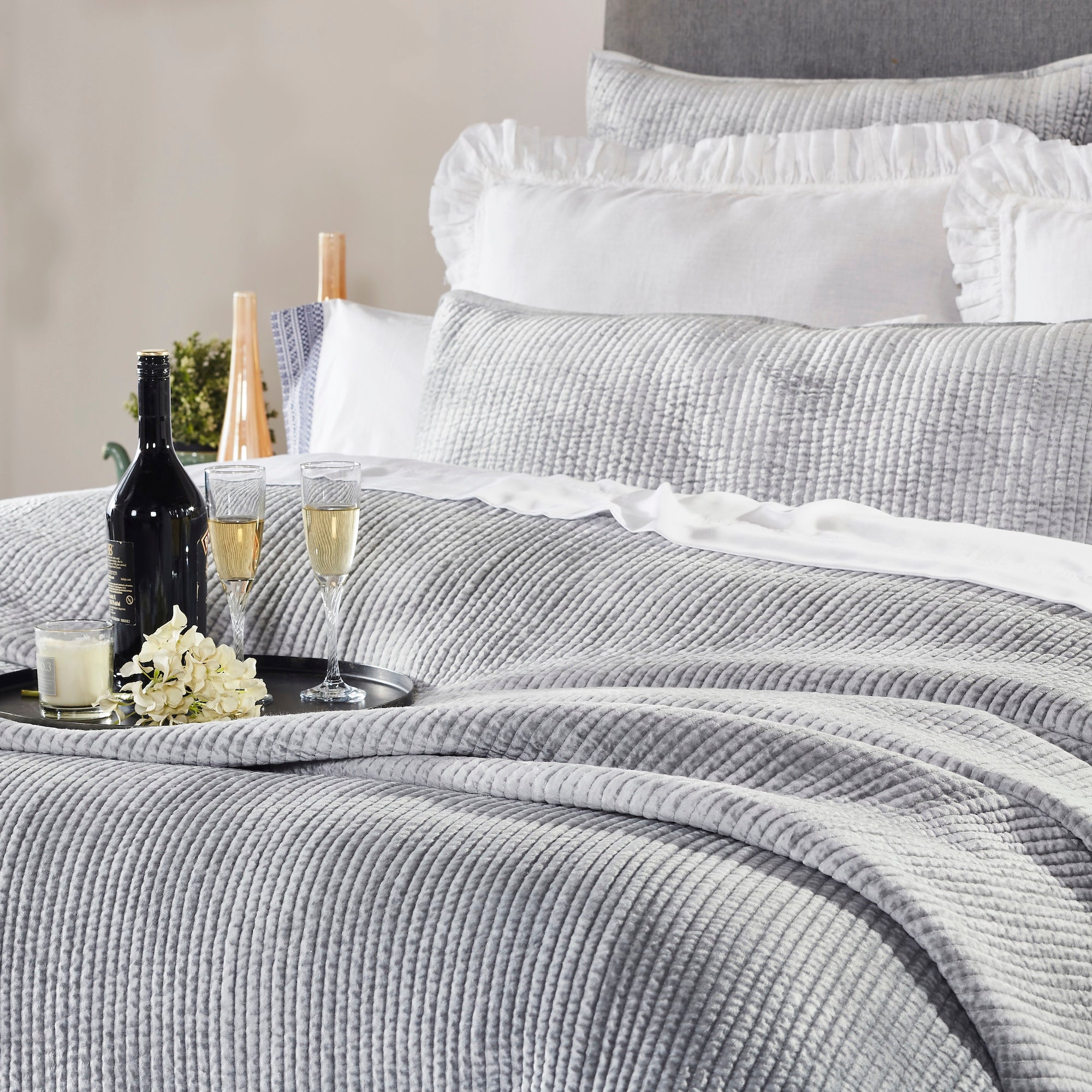 CL-169-11096_3|Luxurious grey textured coverlet on a bed, adorned with wine and champagne, providing stylish quilted warmth for a cozy retreat.