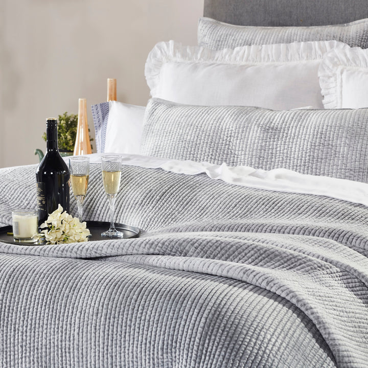 CL-169-11096_3|Luxurious grey textured coverlet on a bed, adorned with wine and champagne, providing stylish quilted warmth for a cozy retreat.