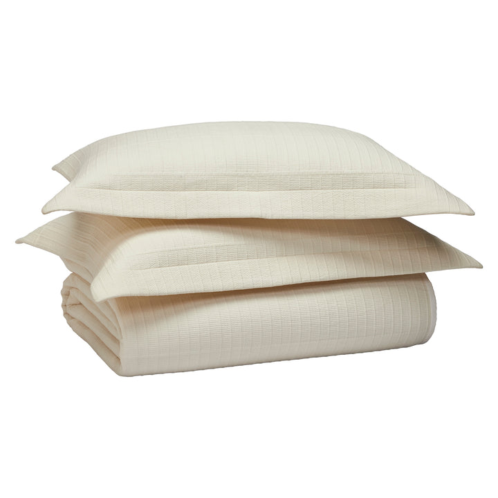 CL-271-11096_13|Stacked cream textured coverlet and two matching pillow shams with ribbed pattern, creating a complete and cozy bedding set.