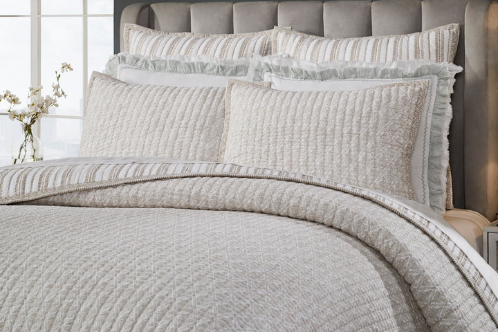 QT-348-9496_3|Full view of a luxurious cream quilt with elegant gold geometric patterns and matching decorative pillows on a king bed.