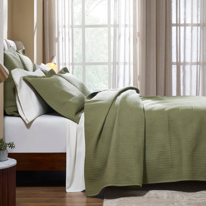 CL-270-9496_3|Side view of a bed dressed with a sage green textured cotton blend coverlet and matching pillows, cozy sleep.