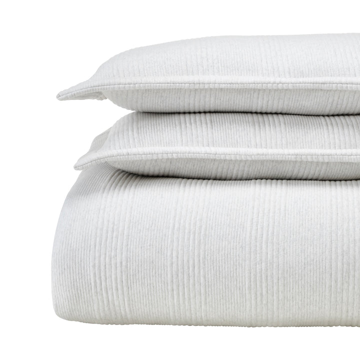 DT-043-10692_5|Stacked light grey ribbed duvet cover, two matching pillows, neatly folded, presenting soft, luxurious bedding.