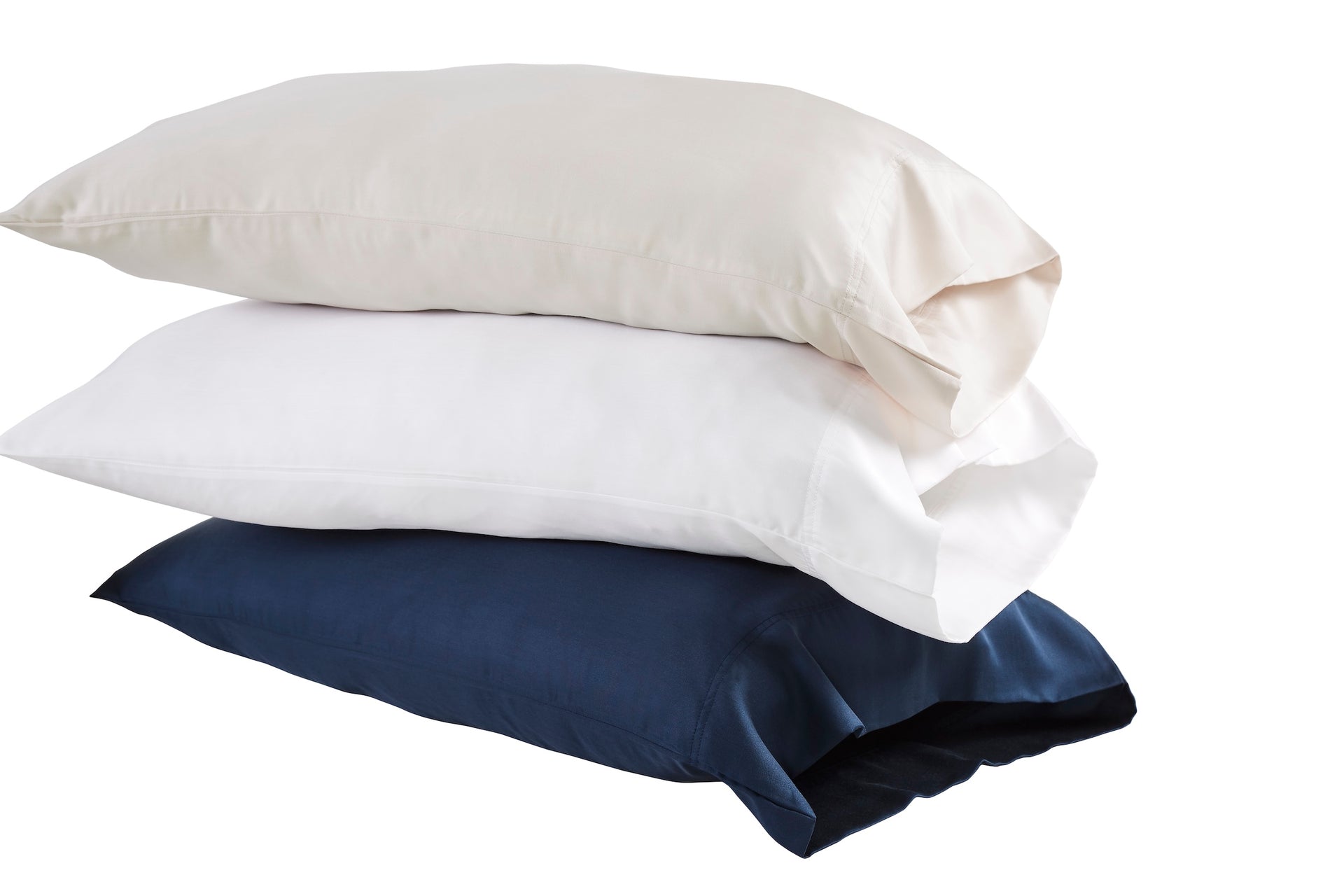 ASP-509-X_1|Stack of three 100% Lyocell pillowcases: pale beige, white, and navy. Each features a smooth sateen weave.