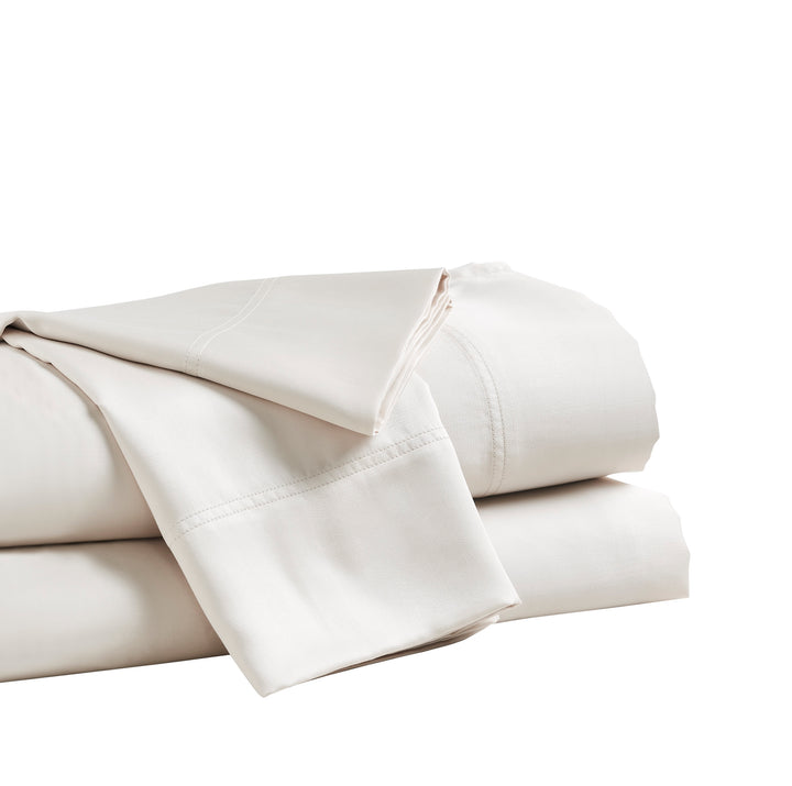 QSS-510-6080_4|Folded stack of light beige 100% Lyocell sheets, featuring a smooth sateen weave and clearly visible tailored hem borders.