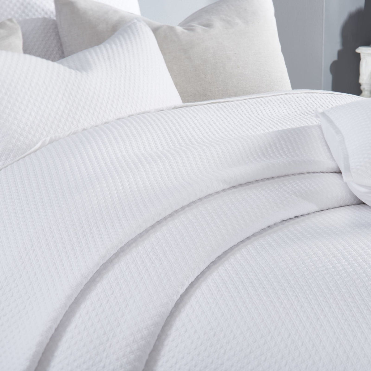 CL-200-9496_4|Detailed view of the pristine white quilted coverlet, highlighting its exquisite diamond pattern and soft fabric.