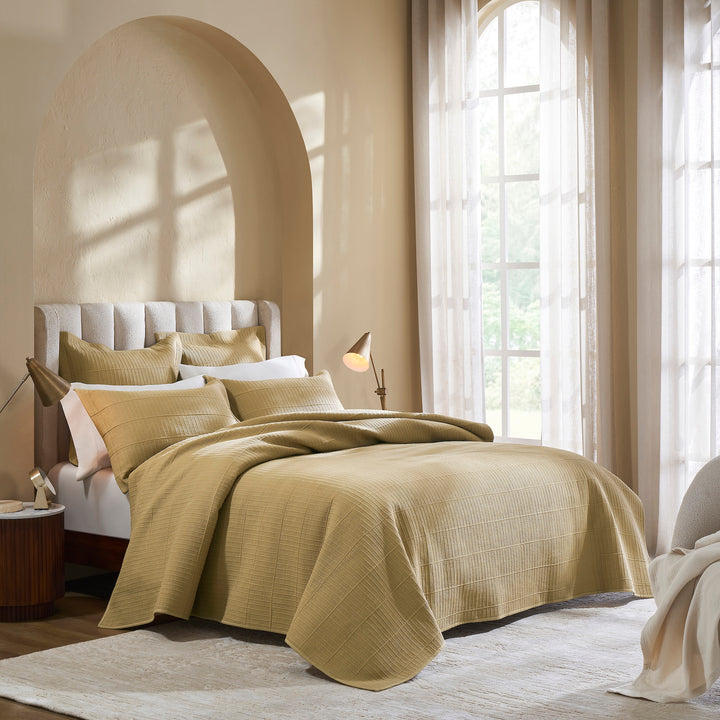 CL-269-11096_1|Gold beige textured quilted coverlet on a bed with matching pillows, enhancing an elegant bedroom's warm ambiance.