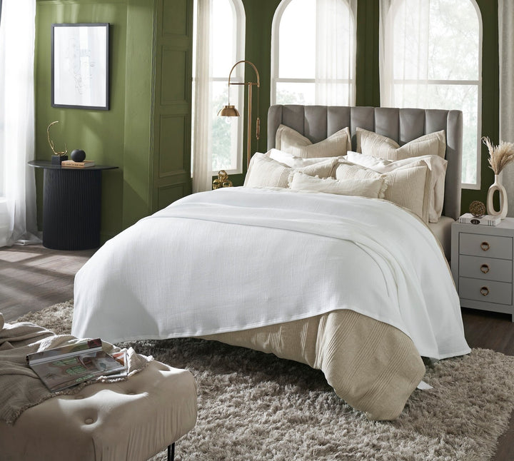BL-858-11096_2|White waffle weave blanket draped casually over a beige comforter in a luxurious green bedroom setting. Perfect for cozy relaxation.
