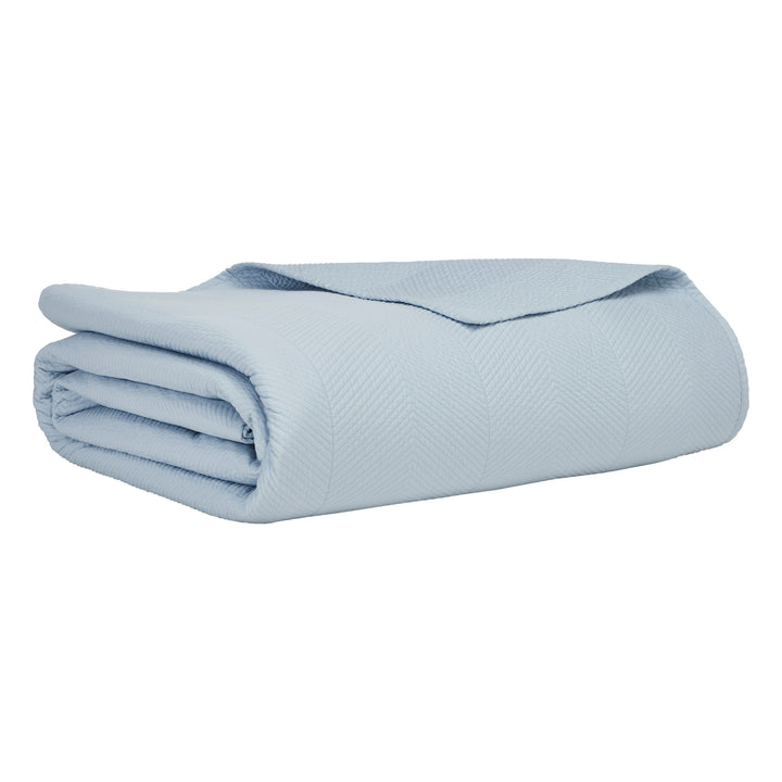 CL-262-11096_6|Light blue quilted coverlet expertly folded, highlighting its subtle herringbone pattern for elegant and comfortable bedding.