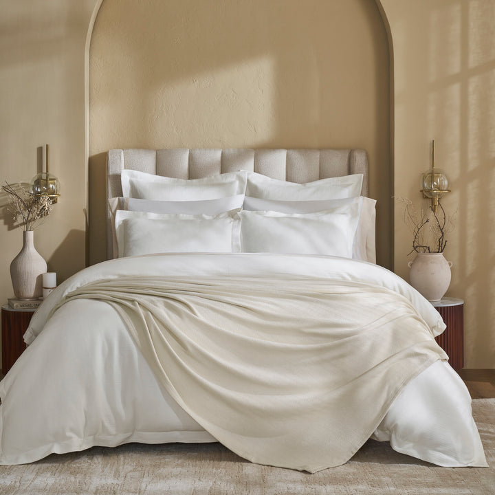 BL-866-11096_1|Cream textured knit blanket draped on white bedding, adding cozy luxury to a neutral bedroom. Perfect for warmth and style.