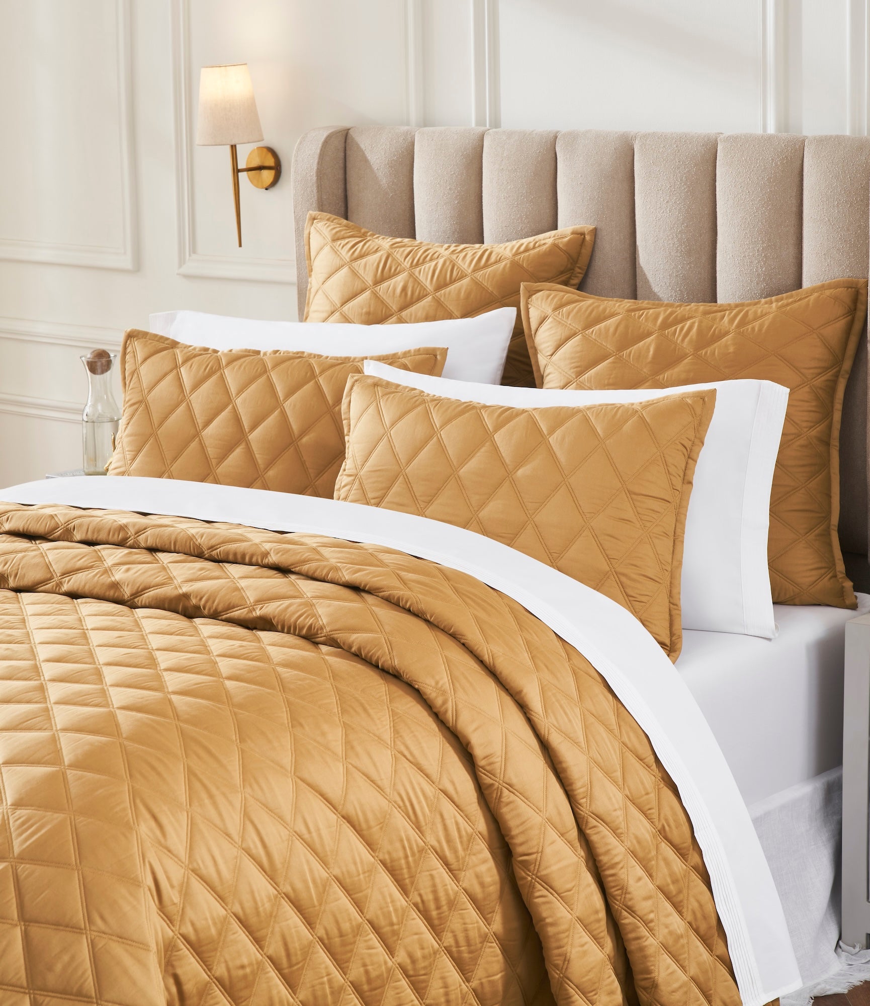 CL-260-11096_3|Close-up of luxurious gold diamond quilted coverlet on a bed, showcasing the rich texture and elegant design.