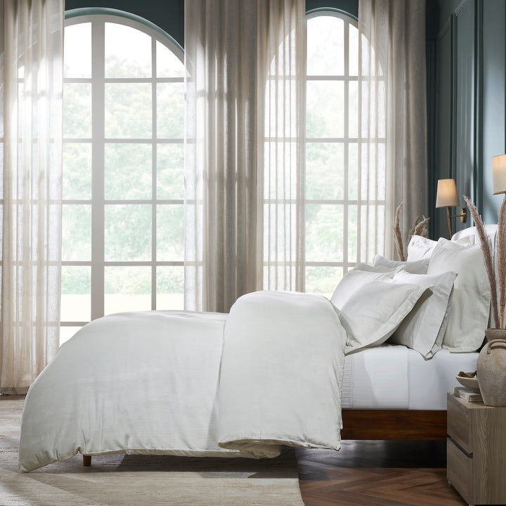 DT-052-9092_3|Elegant white textured duvet cover, featuring a subtle ribbed design, enhancing comfort in a bright bedroom with arched windows.