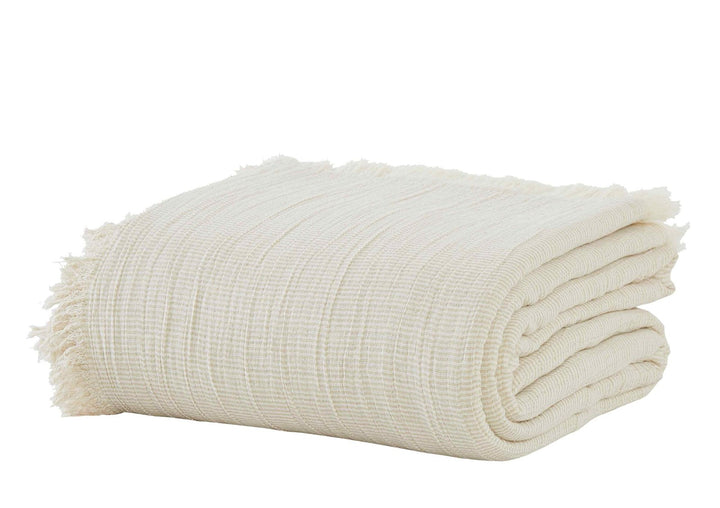 BT-115-11096_2|Soft natural textured throw blanket, folded neatly, featuring stylish fringe details, perfect for adding cozy comfort to any sofa.