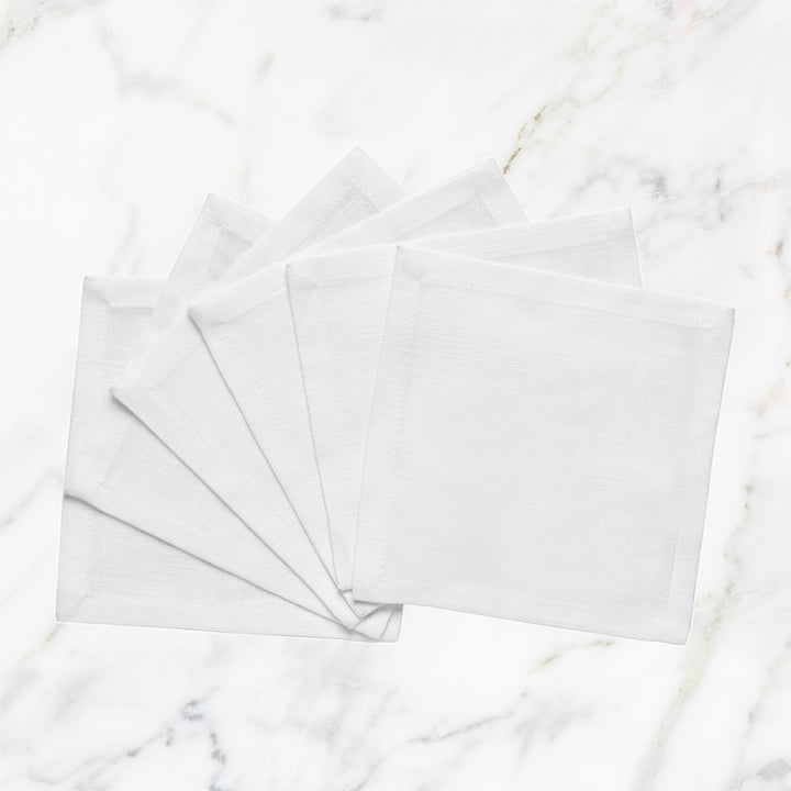 CNP-4909-66_1|Set of fanned white linen napkins displayed on a pristine white marble background for elegant table settings.