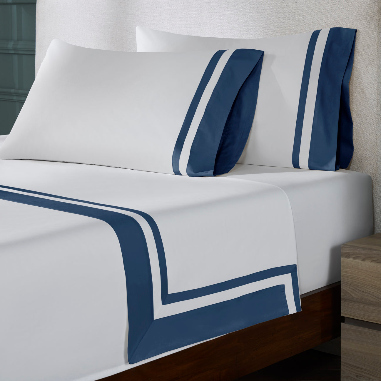 TFL-548-3980_2|Close-up of white 100% cotton sheets with stylish navy blue stripes on a bed. Luxurious, soft, breathable bedding.