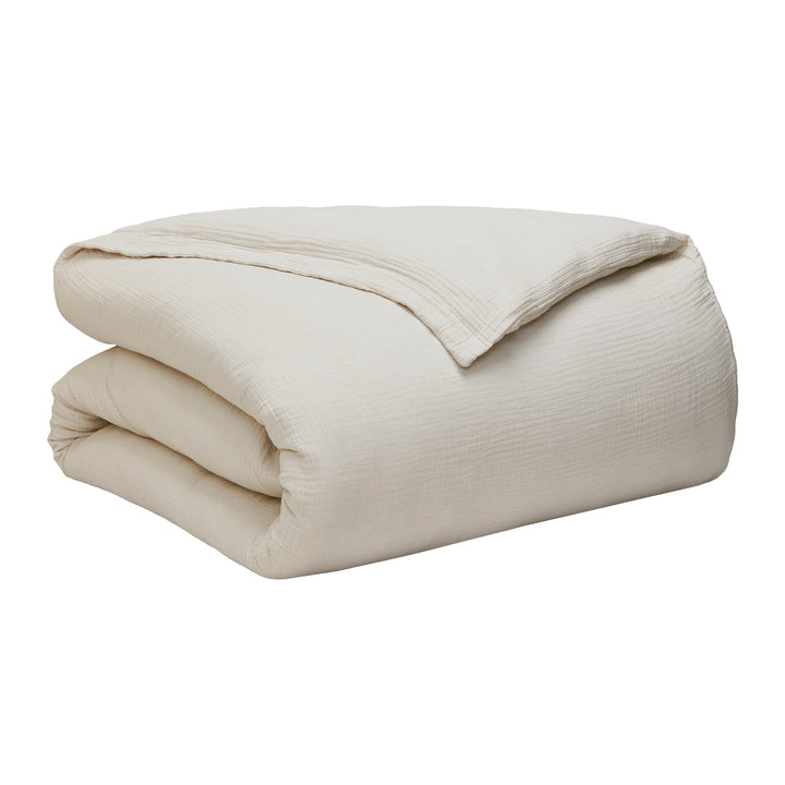 DT-049-10692_10|Folded light cream textured organic cotton gauze duvet cover, showcasing its soft, breathable, and inviting natural fabric.