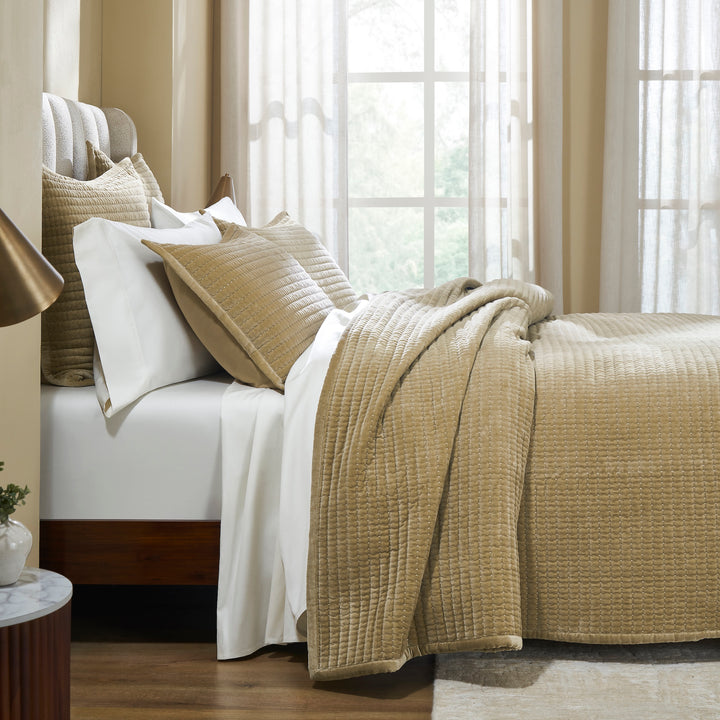 CL-267-11096_3|Close-up of luxurious gold textured quilted coverlet and pillows on a bed. Soft, cozy, and elegant bedding for comfort.