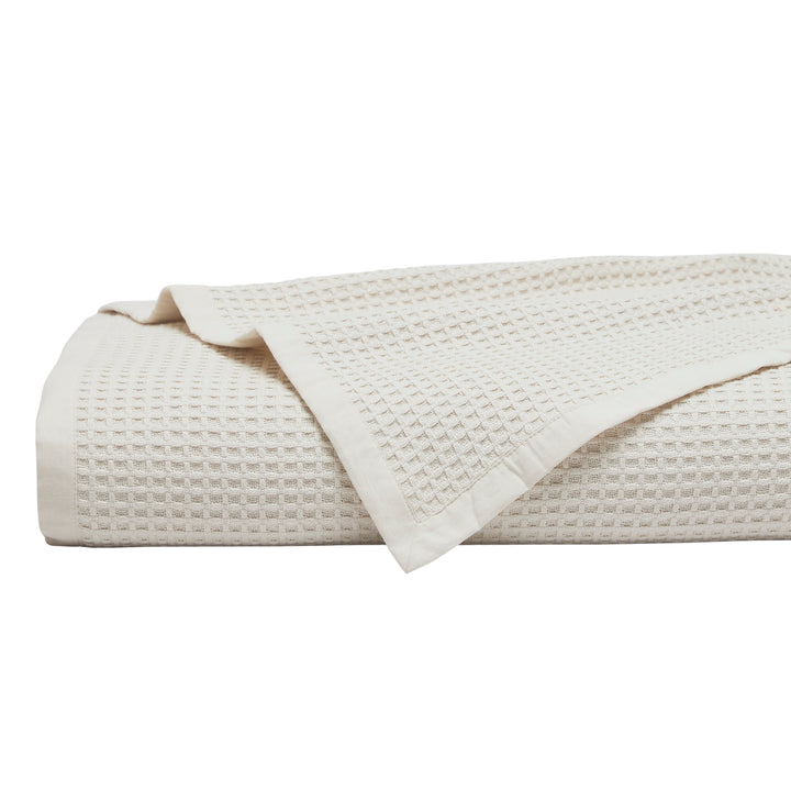 BL-867-9496_1|Folded cream waffle weave blanket. Soft, breathable cotton throw blanket for bed or sofa, adding texture and warmth to any room.