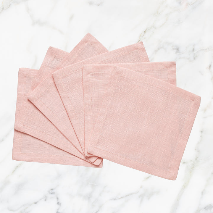 CNP-4910-66_1|Elegant fan of blush pink linen napkins arranged on a classic white marble surface, ideal for sophisticated table settings.