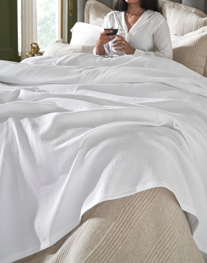 BL-858-9496_5|Crisp white waffle weave blanket on a bed, providing warmth and comfort. Perfect for cozy evenings and relaxation.