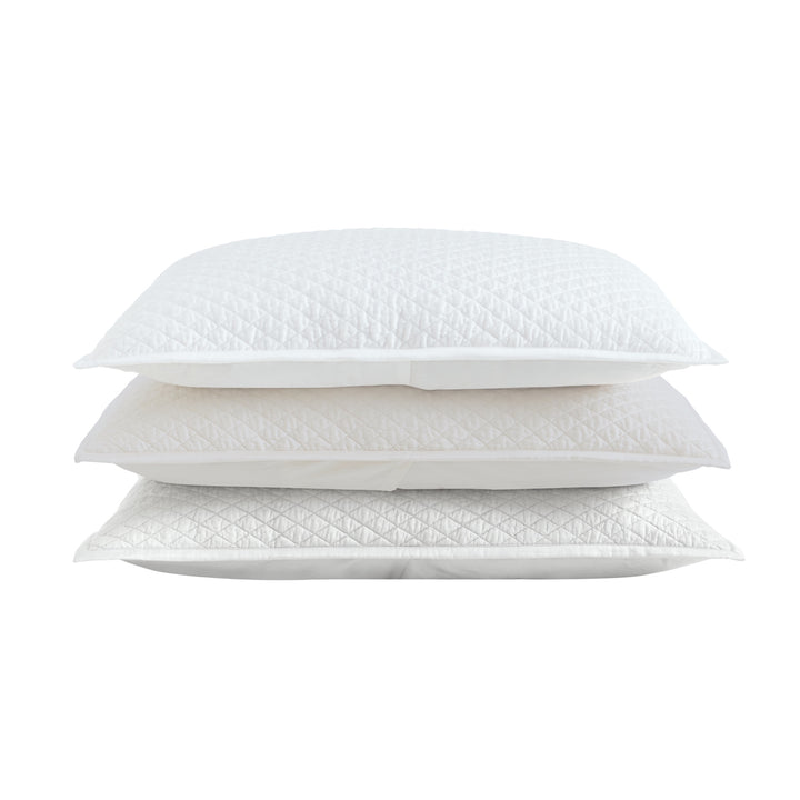 SS-266-2026_2|Stack of white, cream, and grey quilted coverlets with diamond pattern. Versatile bedding options for elegant bedroom styling.