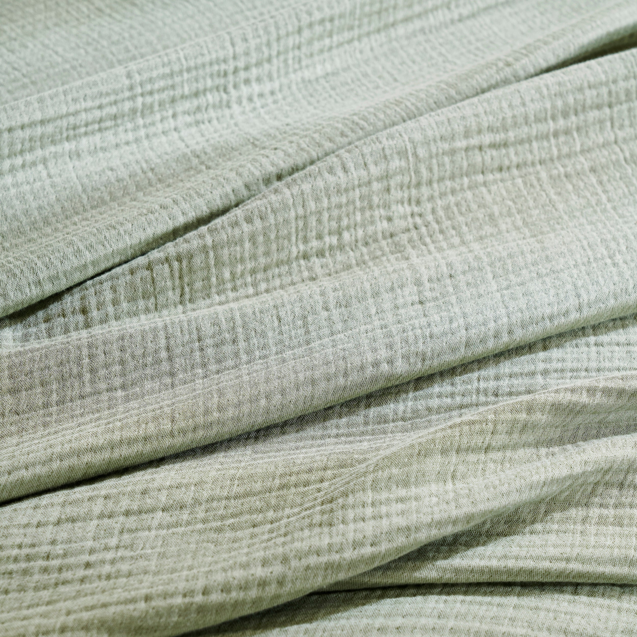 BL-864-9496_5|Detailed close-up of a soft sage green textured blanket, highlighting its cozy crinkled fabric and natural fibers.