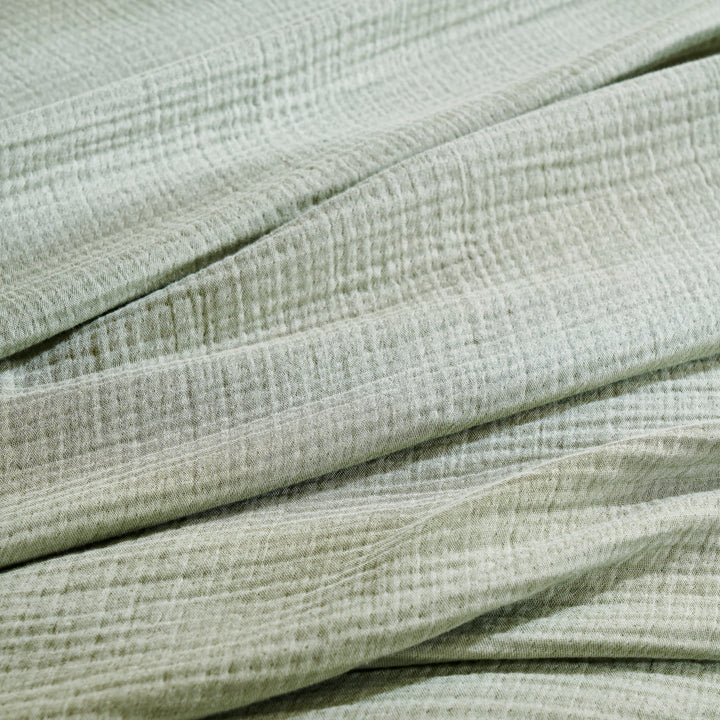 BL-864-9496_5|Detailed close-up of a soft sage green textured blanket, highlighting its cozy crinkled fabric and natural fibers.