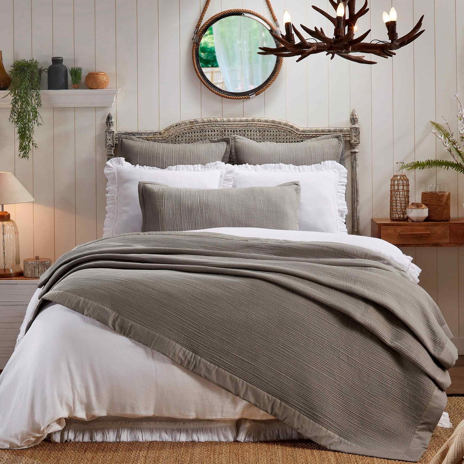CL-162-9496_1|Gray textured coverlet draped over a white bed in a rustic bedroom, adding cozy layering and a touch of elegance.