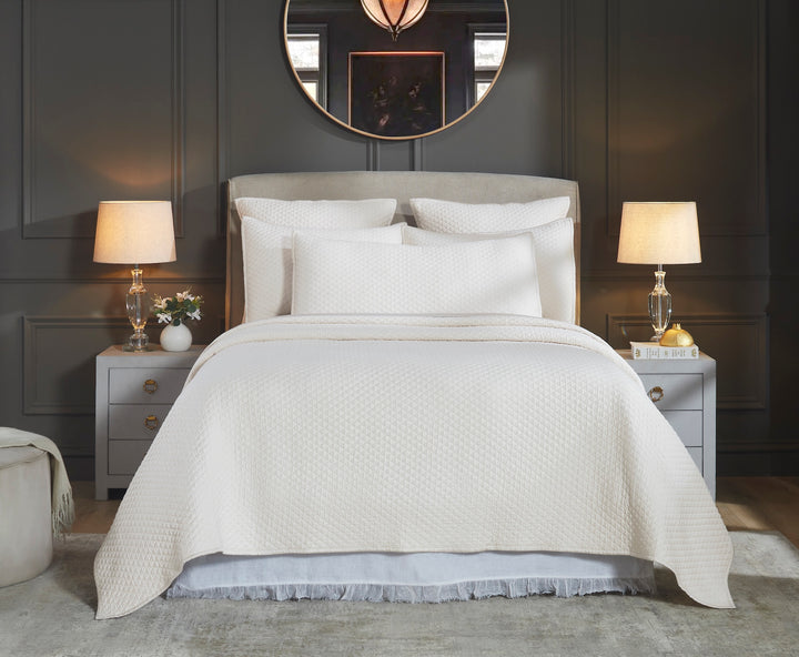 CL-265-11096_1|Full shot of an elegant cream quilted coverlet on a bed, showcasing its beautiful diamond pattern amidst luxurious bedding.