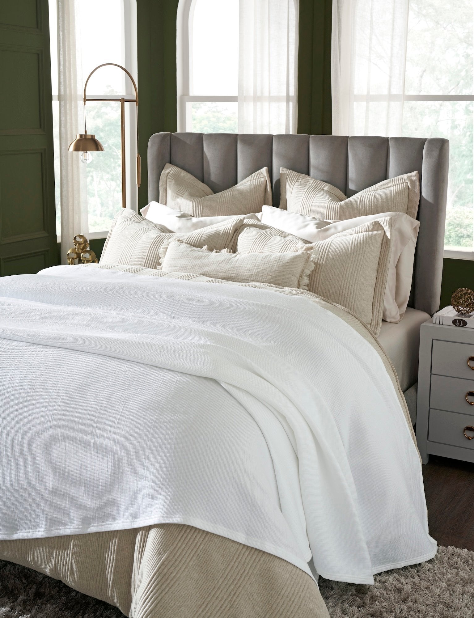 BL-858-9496_3|White waffle weave blanket elegantly draped over a warm beige bed set in a stylish green bedroom. Ultimate comfort.