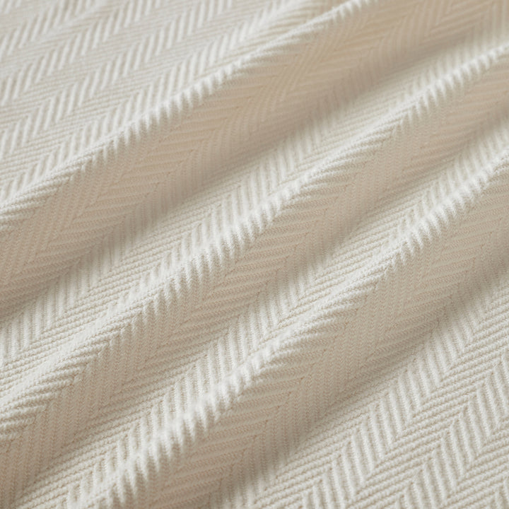 BL-866-9496_9|Close-up of luxurious light beige blanket with a detailed herringbone weave texture, highlighting its soft fabric and pattern.