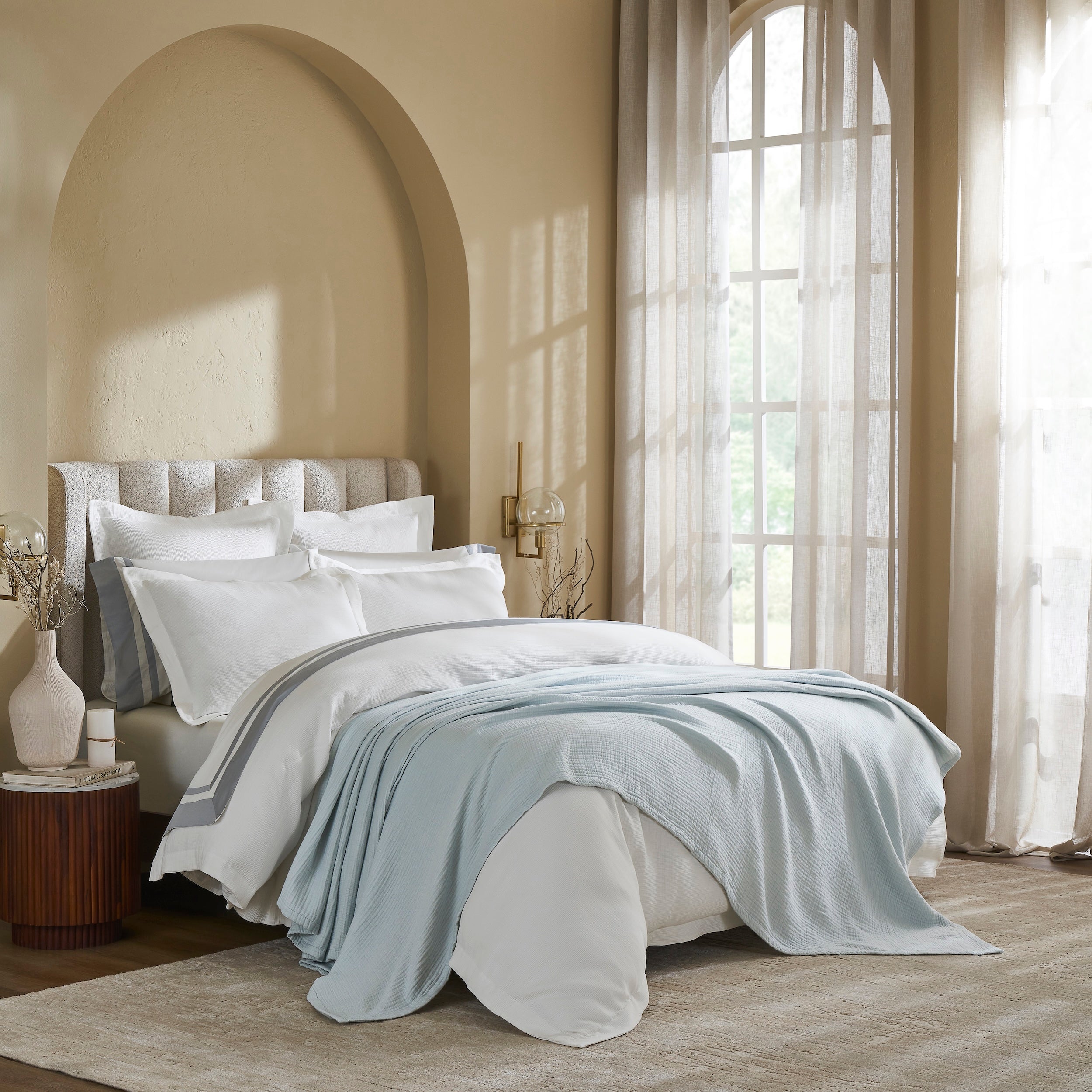 BL-863-9496_3|Soft light blue muslin gauze blanket providing a cozy, breathable layer for comfortable sleep in a modern bedroom setting.