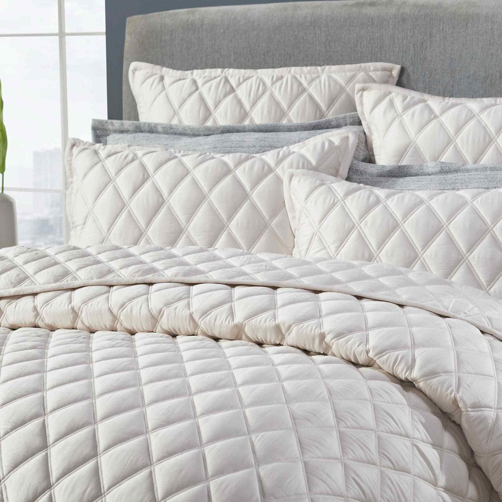 CL-180-11096_3|Close-up of cream diamond-quilted coverlet and pillows, highlighting soft texture and intricate stitching detail.